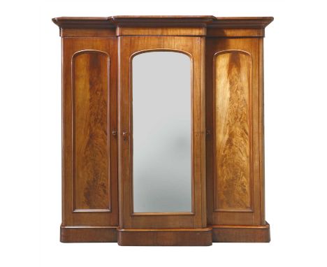 A Victorian mahogany breakfront wardrobe, enclosed by a centre mirror door, flanked by cupboard doors, on a plinth base, 210c