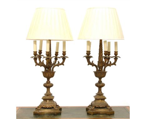 A pair of brass six-light table lamps, each with five arms around a central light on a cast foliate column and square bases, 