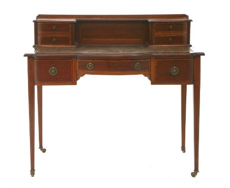 An Edwardian crossbanded and strung mahogany bonheur-du-jour, the shaped back fitted with four trinket drawers, over a leathe
