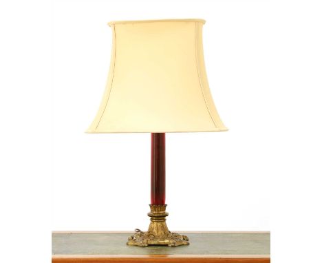 A brass table lamp, with a ruby glass column, a cast base and a silk shade, 74.5cm high overall