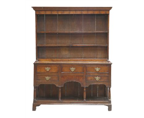 A George III oak pot-board dresser, the closed plate rack with a moulded cornice and original iron hooks, the base with five 