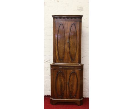 A mahogany floor standing corner cupboard with mirrored slide and raised on bracket feet.