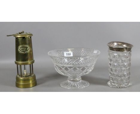 A cut glass pedestal fruit bowl, silver topped vase and a brass cased miners lamp.