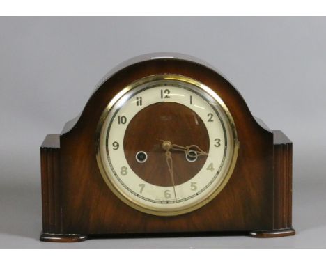 An oak cased mantel clock chiming on a coiled gong.