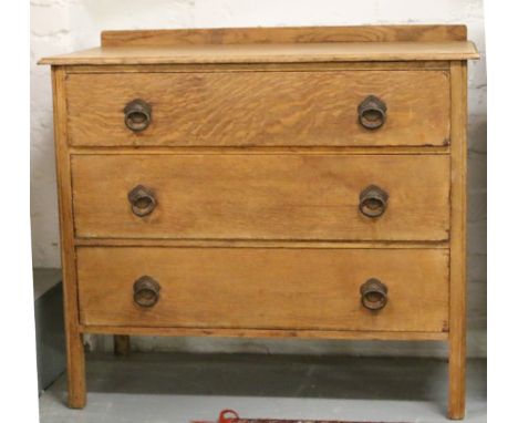 A light oak chest of three drawers, raised on square formed legs.