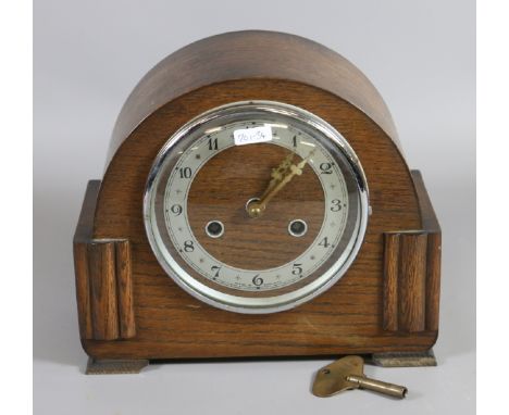 An oak cased mantel clock chiming on a coiled gong by Bentina, England.