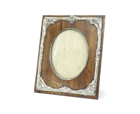 Art Nouveau inspired silver and fruitwood photograph frame, the oval aperture within an applied repousse foliate surround, im