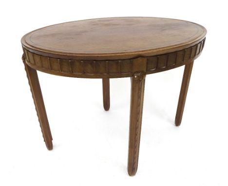 Unusual Art Deco period oval mahogany occasional table, the top inlaid with an ebony strung band, the moulded carved frieze u