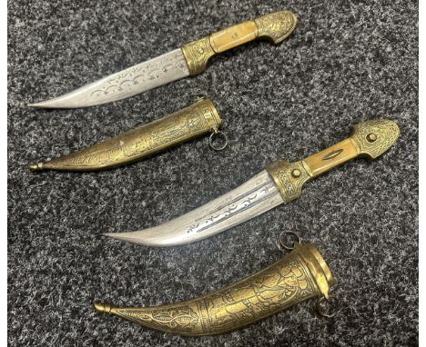 Two Middle Eastern Jambiya Daggers. Each made of brass and with inlaid Horn grips. Both with curved decorated blades, one 154