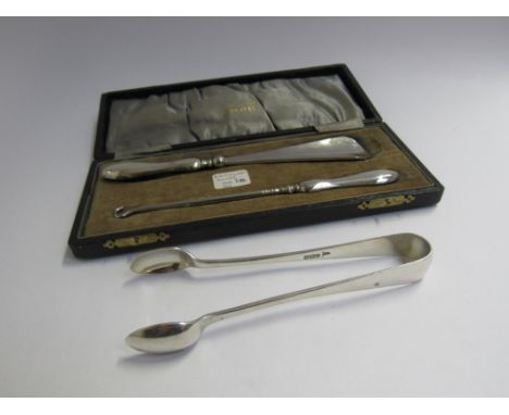 A cased silver handled shoe horn and button hook, Birmingham 1920 and a pair of Walker &amp; Hall silver sugar tongs Sheffiel