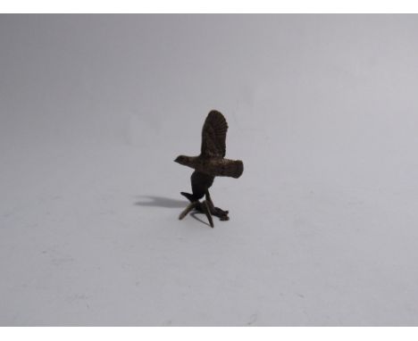 A miniature solid bronze flying partridge, 5cm tall 