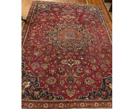 An early to mid 20th century large hand-knotted medallion carpet, woolen pile, central medallion to a claret field and blue s