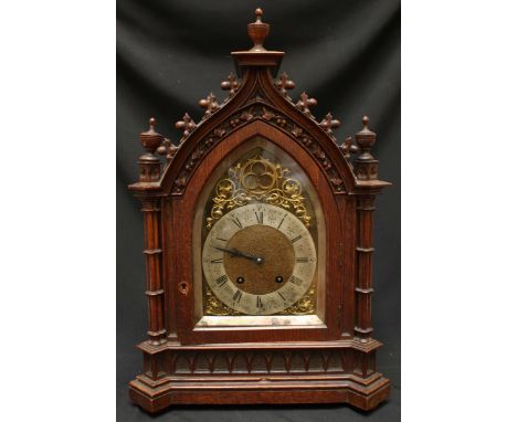 A Victorian oak cased Gothic design mantle clock, with arched brass dial and silvered chapter ring, set within a carved oak G