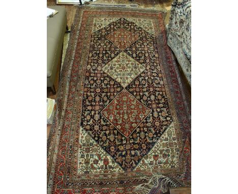 A South Western Persia Kashquai wool carpet, early to mid 20th century, dark blue ground with triple lozenge medallion within