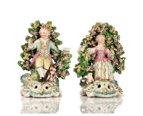A PAIR OF DERBY CANDLESTICK FIGURESCirca 1770Modelled as a young shepherd and shepherdess seated before a flowering bocage, a
