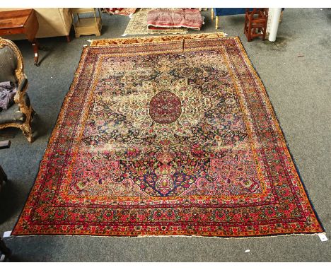 A KERMAN CARPET, PERSIANThe indigo field with a bold ivory medallion, pink spandrels, all with floral sprays; a brown floral 