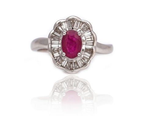 AN 18CT WHITE GOLD, RUBY AND DIAMOND SHAPED OVAL CLUSTER RINGClaw set with the oval cut ruby in an undulating oval surround, 