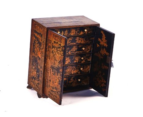 A 19TH CENTURY CHINESE-EXPORT CHINOISERIE DECORATED TABLE CABINETThe pair of doors enclosing seven drawers, 46cm wide; 57cm h