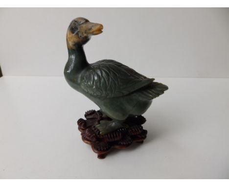 A Chinese jade  study of a goose on ornately carved wooden stand, 5” high overall.
