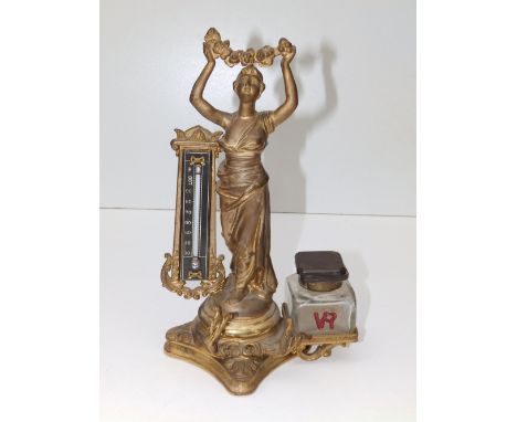 A Victorian gilt brass figural deskstand with thermometer and inkwell to base – 'VR', 9.5” high.