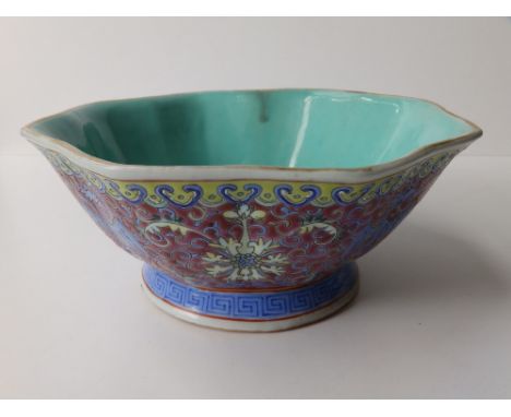 An octagonal Chinese porcelain polychrome enamelled bowl, the deep pink exterior decorated small blue dragons between large f