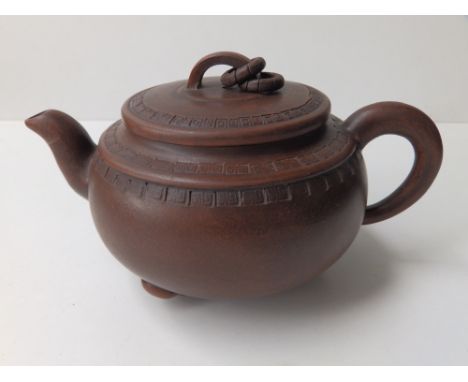 A Chinese red stoneware circular teapot with two loose hoops modelled to handle, three seal marks to underside, 7.5” across h