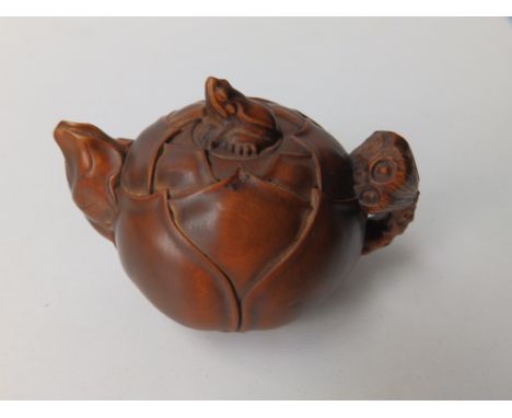 An Oriental carved wood miniature teapot in the form of a lily pad surmounted by a frog,  3” across.