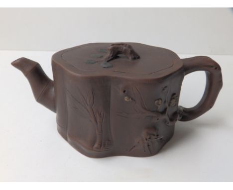 A Chinese red stoneware teapot of tree trunk outline, impressed circular seal mark, 7.5” across handle.