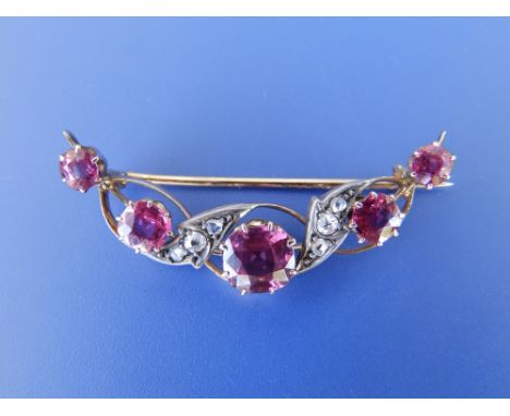 A late 19th/early 20thC ruby & diamond openwork crescent brooch. 1.7”