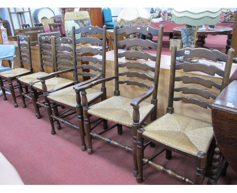 A Set of Six (four single and two carver) Country Style Dining Chairs, each with wavy ladder back and rush seat.