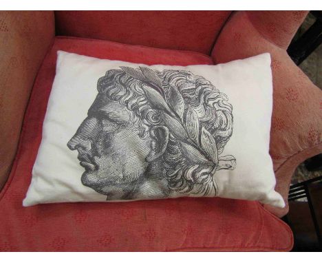 A cushion with images of Romans wearing laurel wreaths   