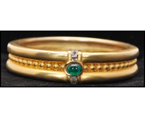 A vintage signed Givenchy runway gold-tone bangle bracelet set with an emerald green Gripoix cabochon with square cut white a