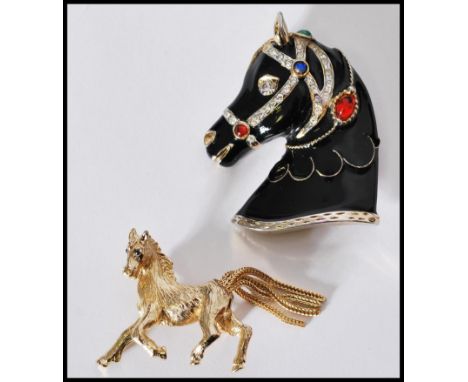 A vintage signed Sphinx gold tone figural brooch in the form of a stallion with tassel tail and gem set eyes, together with a