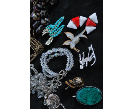 An assortment of vintage costume jewellery, beads and fittings. To include a large enamelled locket pendant signed Art, vinta