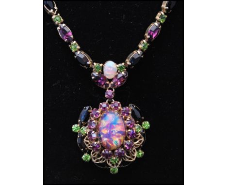 A 1920s faux opal suffragette necklace having a central faux opal surrounded by a halo of purple rhinestones set in raised fi