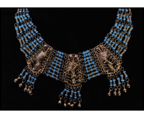 A vintage gold tone Egyptian style bib necklace with three large filigree work panels set with Pharaoh heads with tassel drop