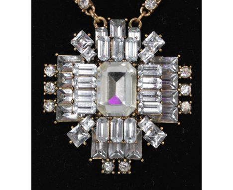 A vintage rhinestone set gold-tone necklace with large 3D cross pendant set with baguette and round cut rhinestones on a snak