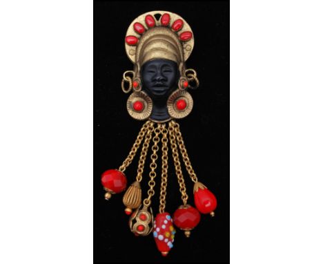 A vintage signed Askew of London figural brooch pin in the form of a blackamoor with beaded hair braids. Measures 5 inches.