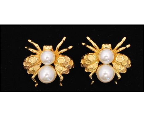 A vintage pair of signed Napier gold-tone bee bug brooches set with faux pearl with hexagonal design to wings. Measures 1 1/4
