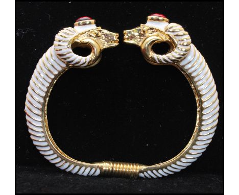 A 1990s signed Kenneth J Lane rams head clamper bracelet bangle with enamel and red cabochon decoration complete with box and