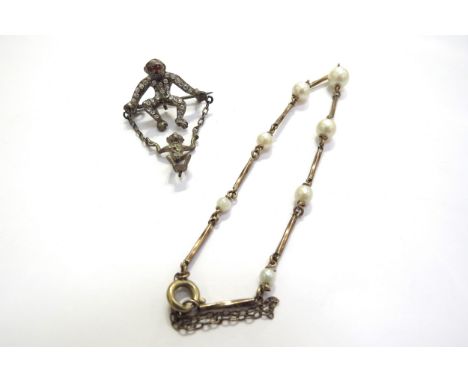 A pearl and gold bracelet, unmarked, 18cm long and a paste set brooch as a monkey with its baby on a swing 