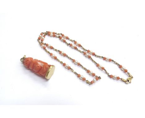 A coral and pearl bead gold necklace stamped 14k, 40cm long with a carved coral Buddha pendant 