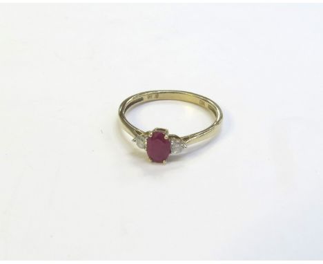 A ruby and diamond ring, the central oval ruby flanked by round cut diamonds, stamped 9k. Size O, 1.5g 
