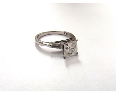 A white gold princess cut diamond solitaire ring 1ct approx, with tapering baguette diamonds to shoulders, marked 18k. Size K