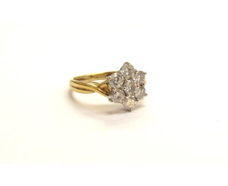 An 18ct gold diamond daisy ring, 10mm diameter. Size M/N, 4.2g 