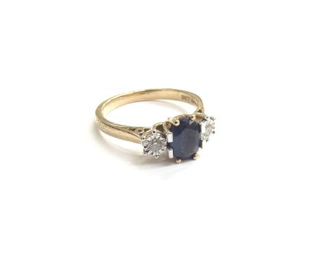 A 9ct gold sapphire and diamond ring, the central oval sapphire flanked by diamonds. Size M, 2.7g 