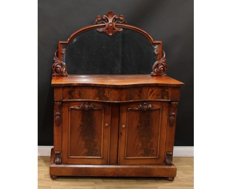 A Victorian mahogany chiffonier, the mirror frame carved and applied with scrolling leaves, serpentine top above a frieze dra