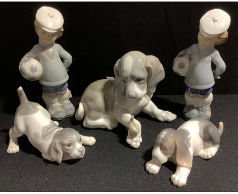 A large Lladro figure of a puppy, 15cm high; others; two Lladro figures of boy and football (5) 