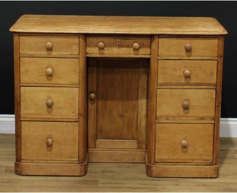 A pine kneehole desk, rectangular top with moulded edge above an arrangement of nine short drawers, the niche with a rectangu