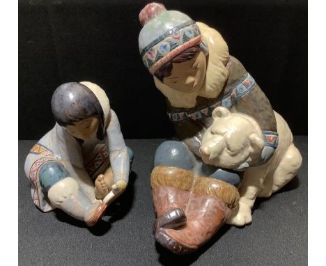 A large Lladro figure of a boy and polar bear, 24cm high;  another of an Inuit (2) 